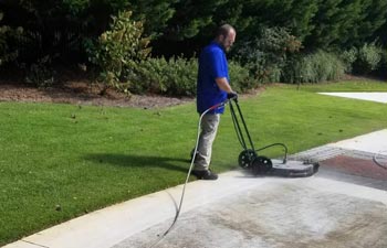 Alpharetta Pressure Washing worker cleaning concrete paver