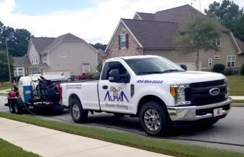 Alpharetta Pressure Washing truck with wquipment parked in front of a residential house